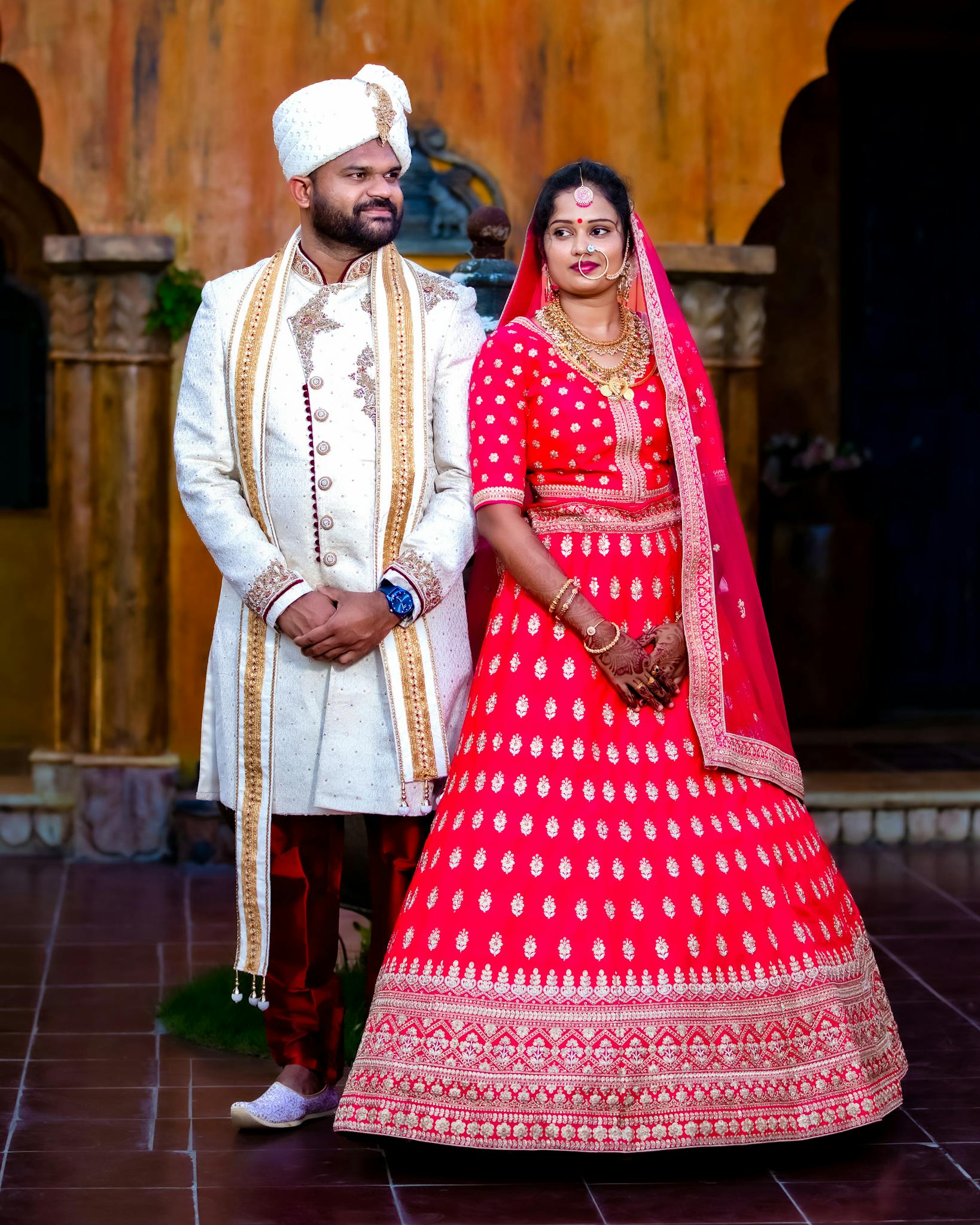 Elegant couple in traditional attire at a festive wedding ceremony.
